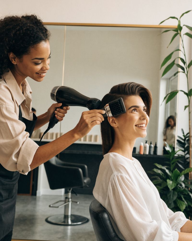 Hairstylist finishing a client's blow-dry in a modern salon
